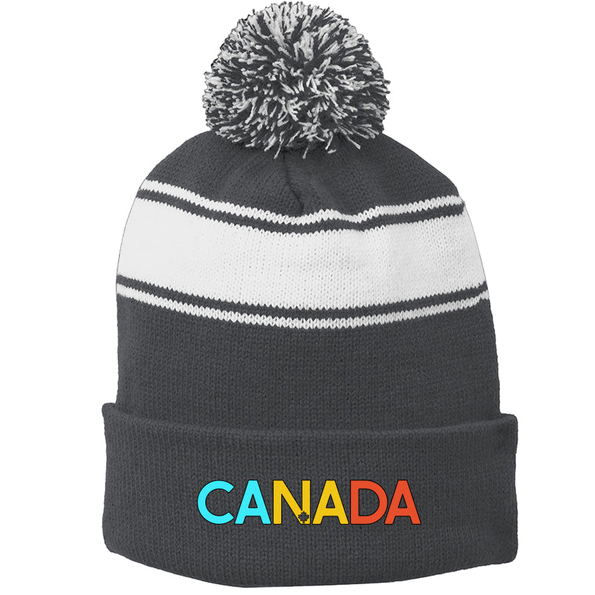 Black and white striped beanie with pom-pom and 'Canada' embroidered on a white background