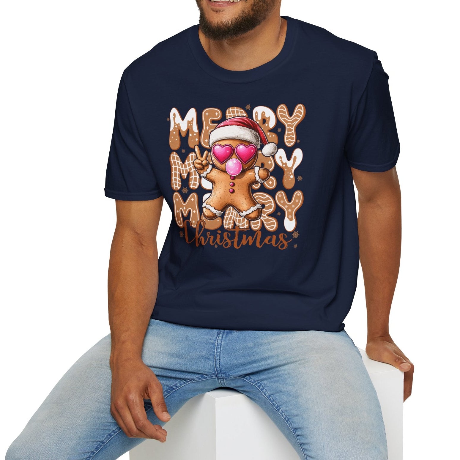 Man wearing a navy blue t-shirt with 'Merry Christmas' design sitting on a white stool.