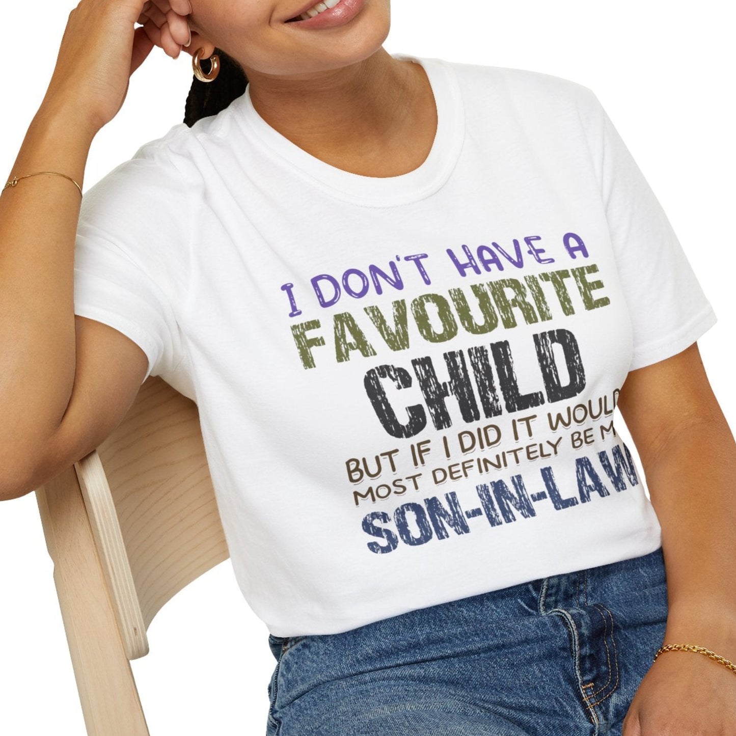 Person wearing a white t-shirt with humorous text, sitting on a chair.
