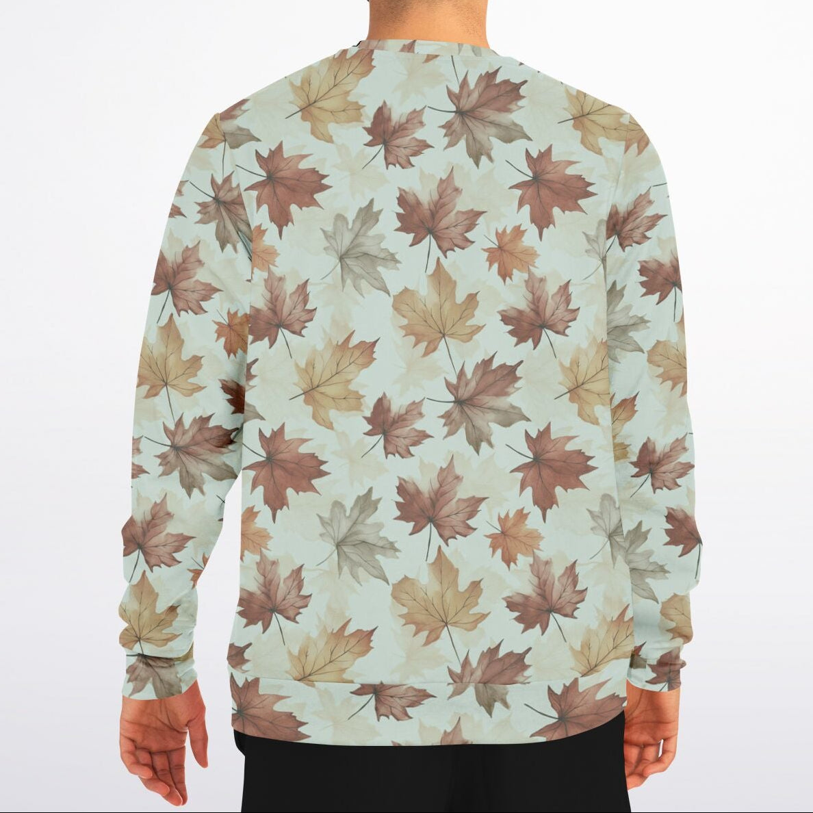 Person wearing a sweater with a leaf pattern on a plain background