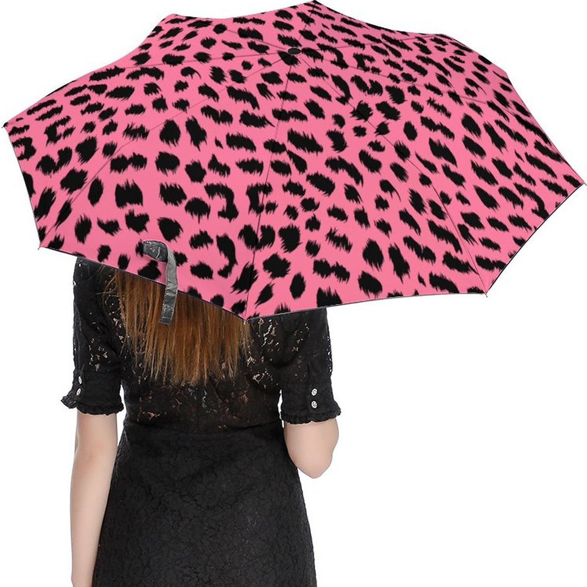 Person holding a pink umbrella with black leopard print pattern on a white background