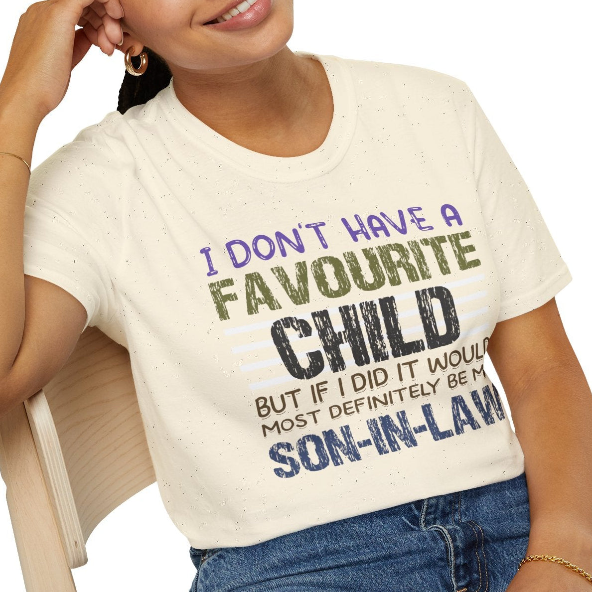 Person wearing a natural t-shirt with humorous text design, sitting on a chair.