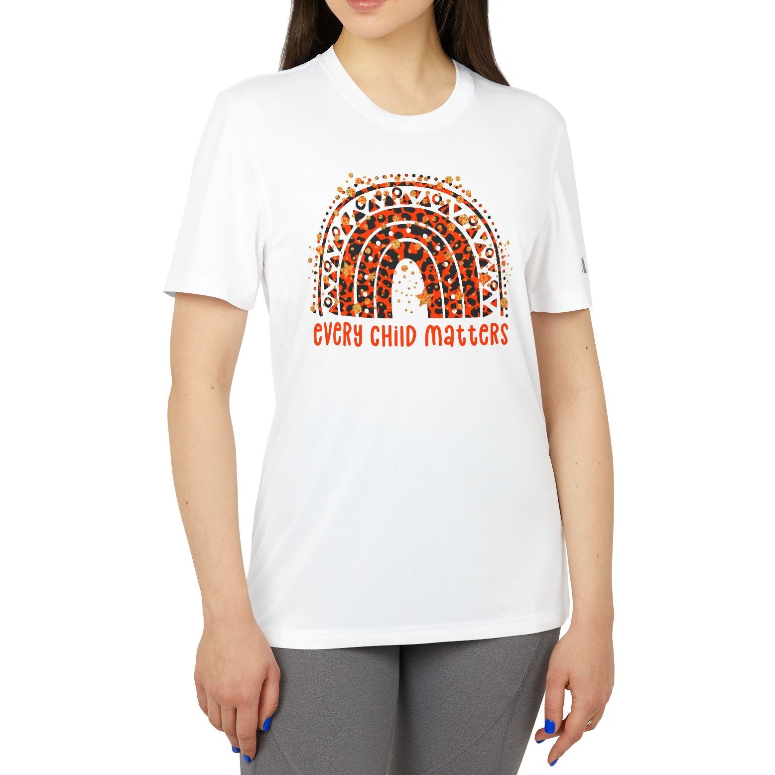 Woman wearing a white t-shirt with a rainbow design and 'Every Child Matters' text on a white background