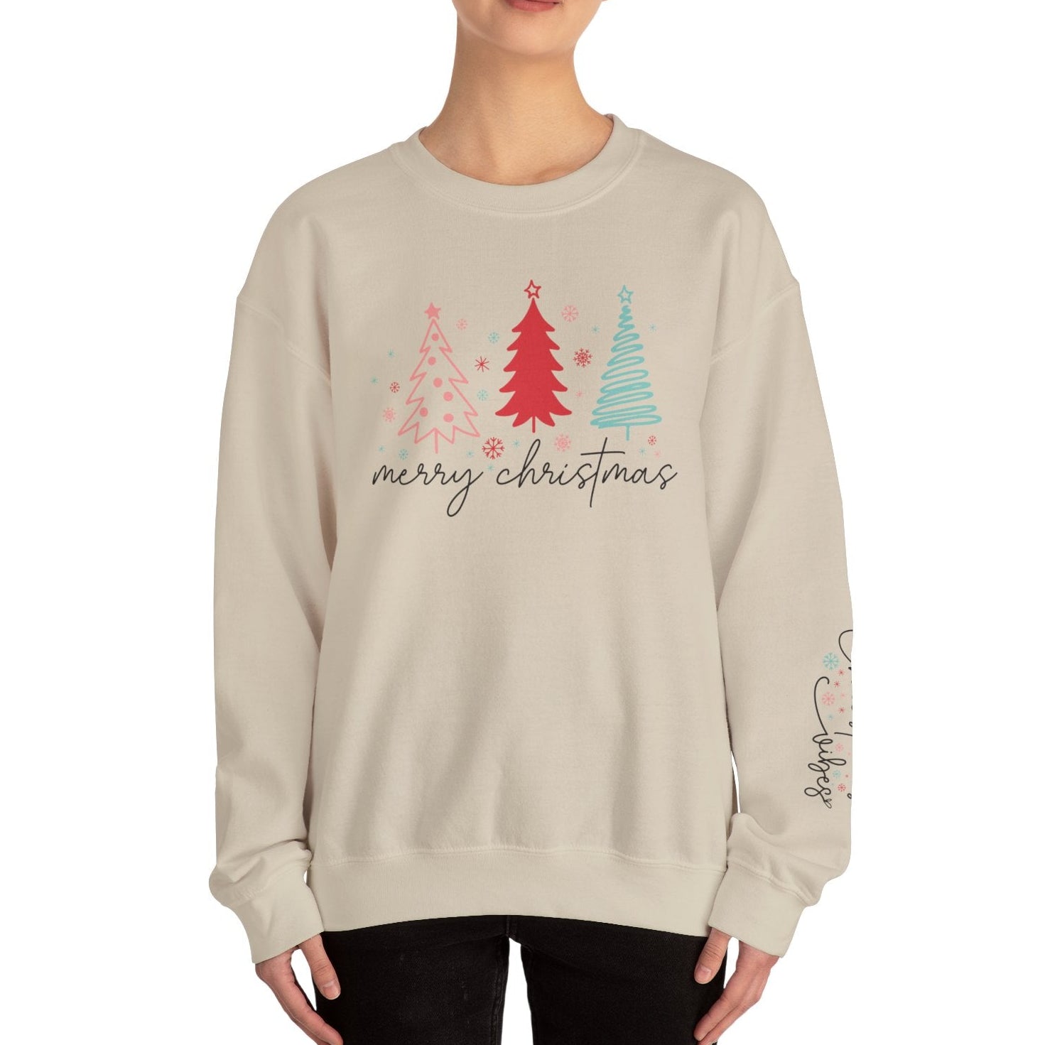 Person wearing a beige sweatshirt with Christmas tree design and 'merry christmas' text on a white background