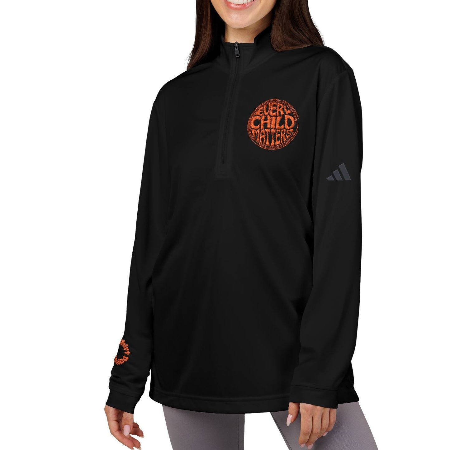 Woman wearing a black hoodie with orange text and Adidas logo on a white background
