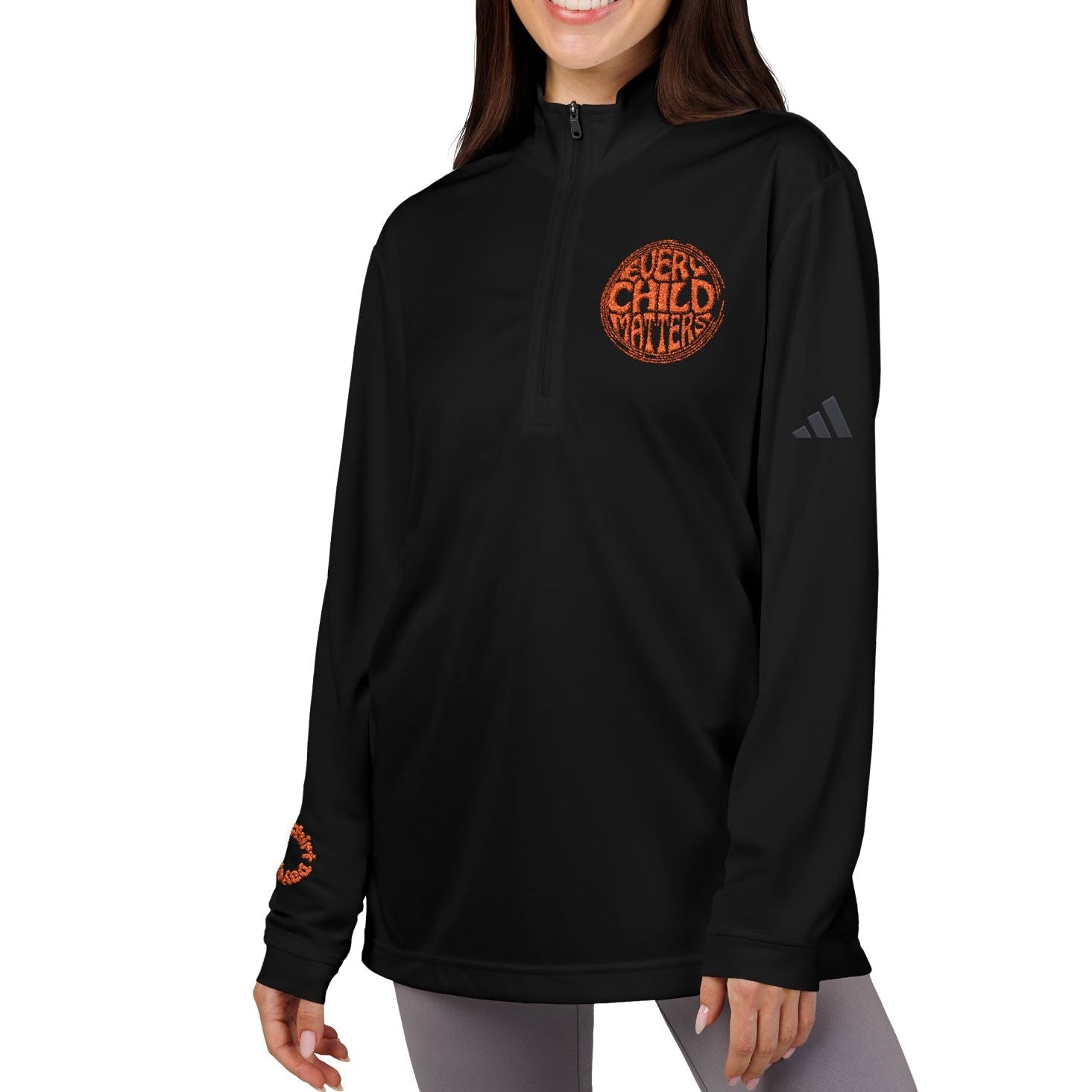 Woman wearing a black hoodie with orange text and Adidas logo on a white background