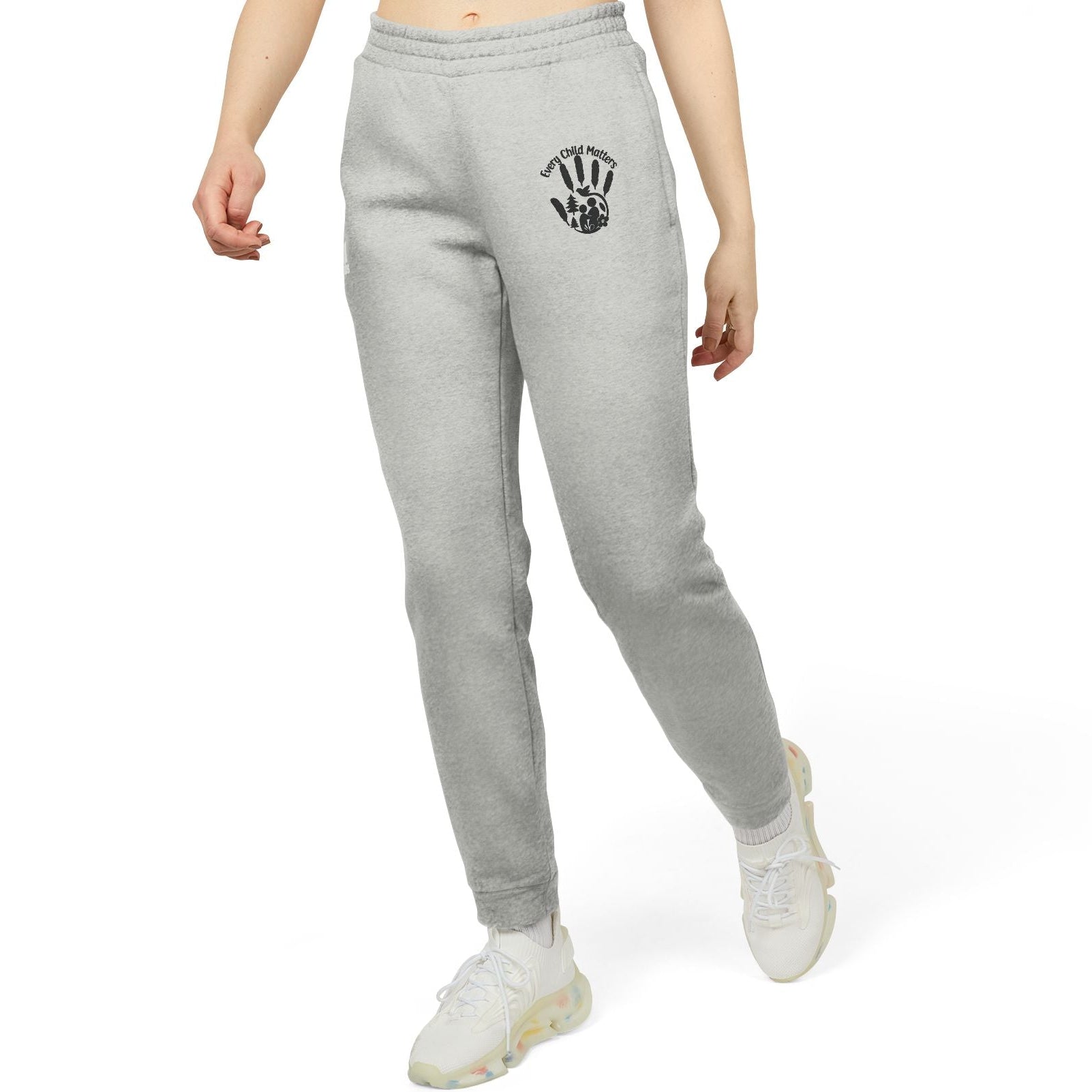 Person wearing gray sweatpants with a logo on a white background