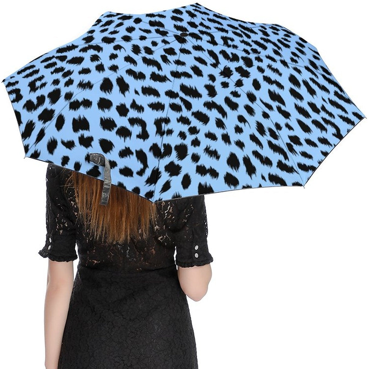 Person holding a blue umbrella with black leopard print pattern on a white background