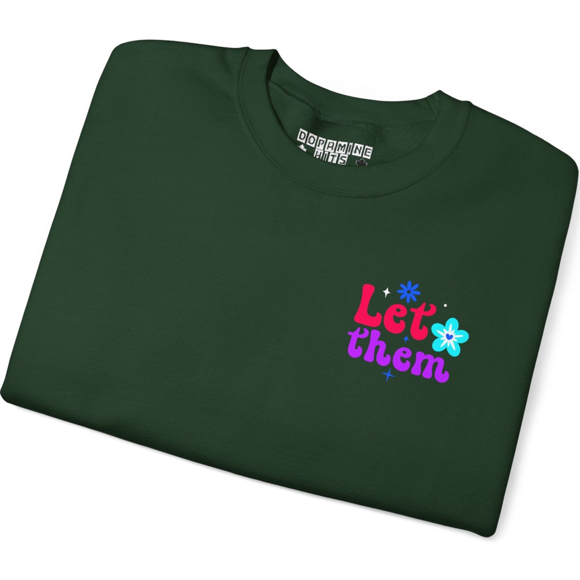 Folded green t-shirt with colorful text and graphics on a white background