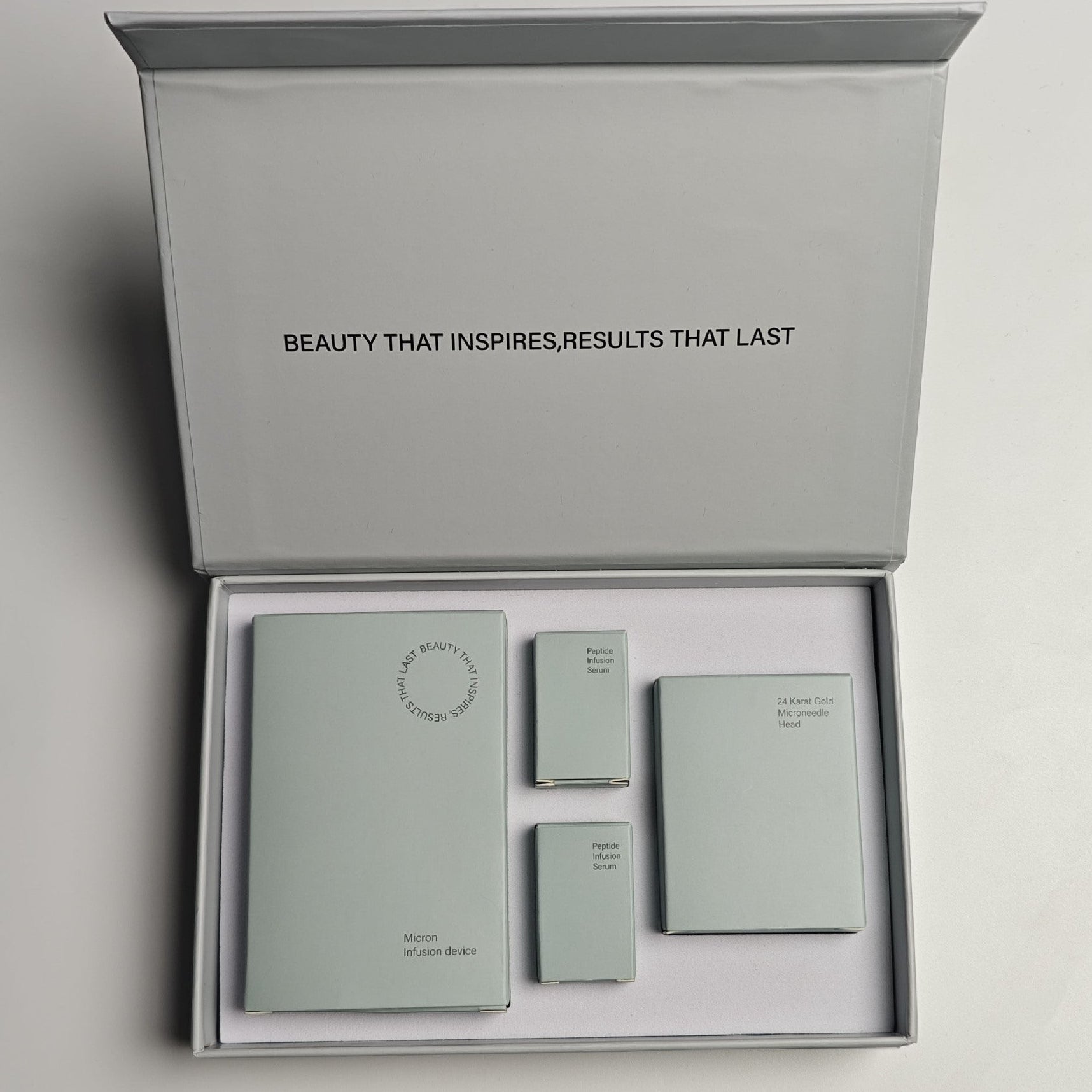Set of skincare products in a gray box with 'Beauty That Inspires, Results That Last' text.