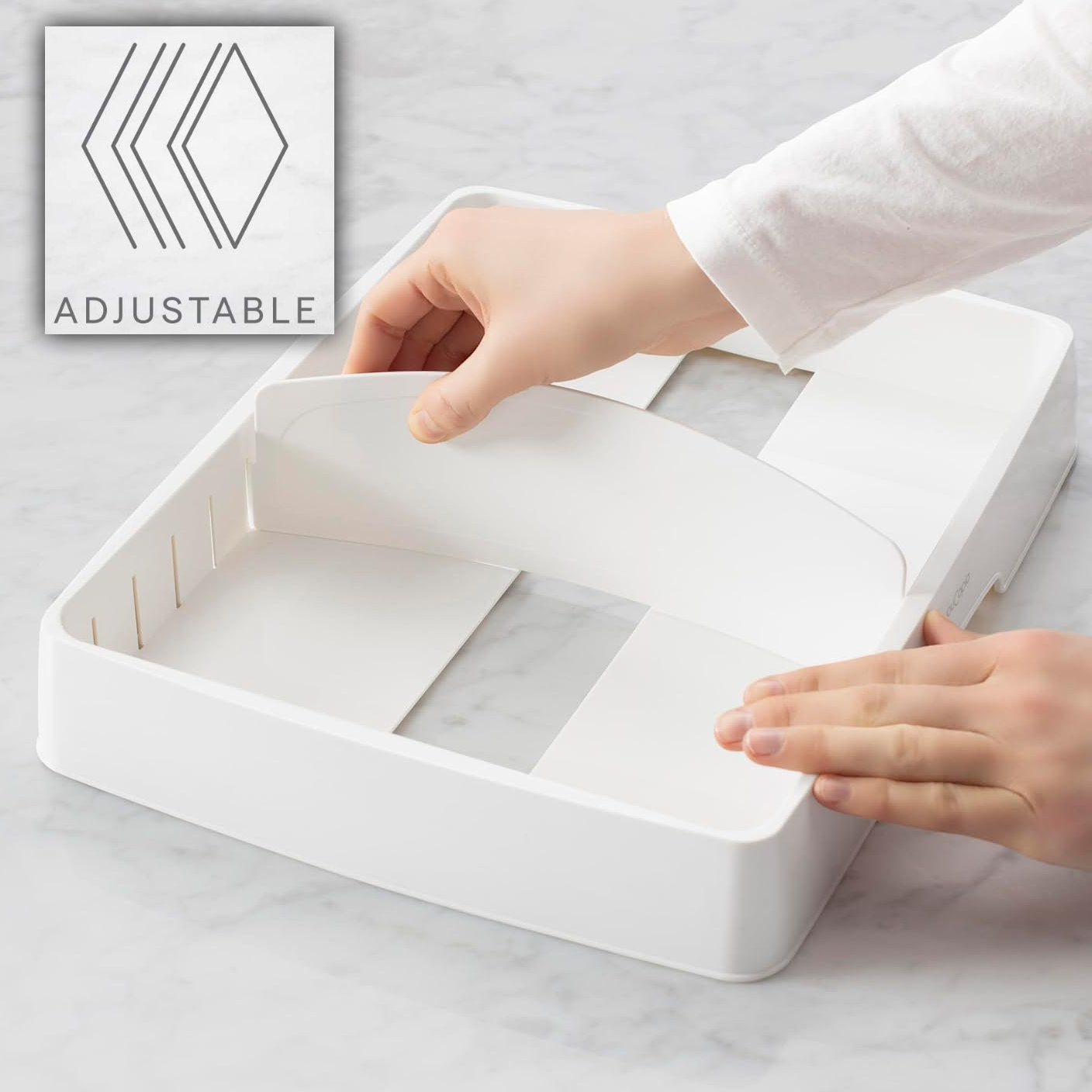 White adjustable tray with hands demonstrating its use on a light gray surface.