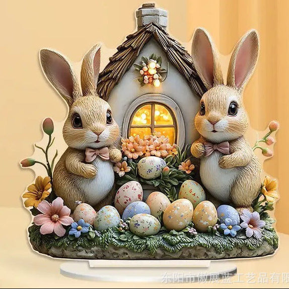 Decorative figurine of two rabbits with a small house and Easter eggs on a yellow background