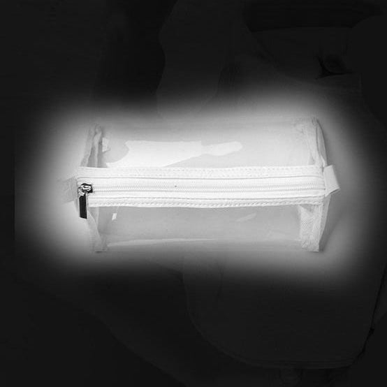A small clear zippered pouch or organizer bag shown against a dark background with a faint person seated behind it.