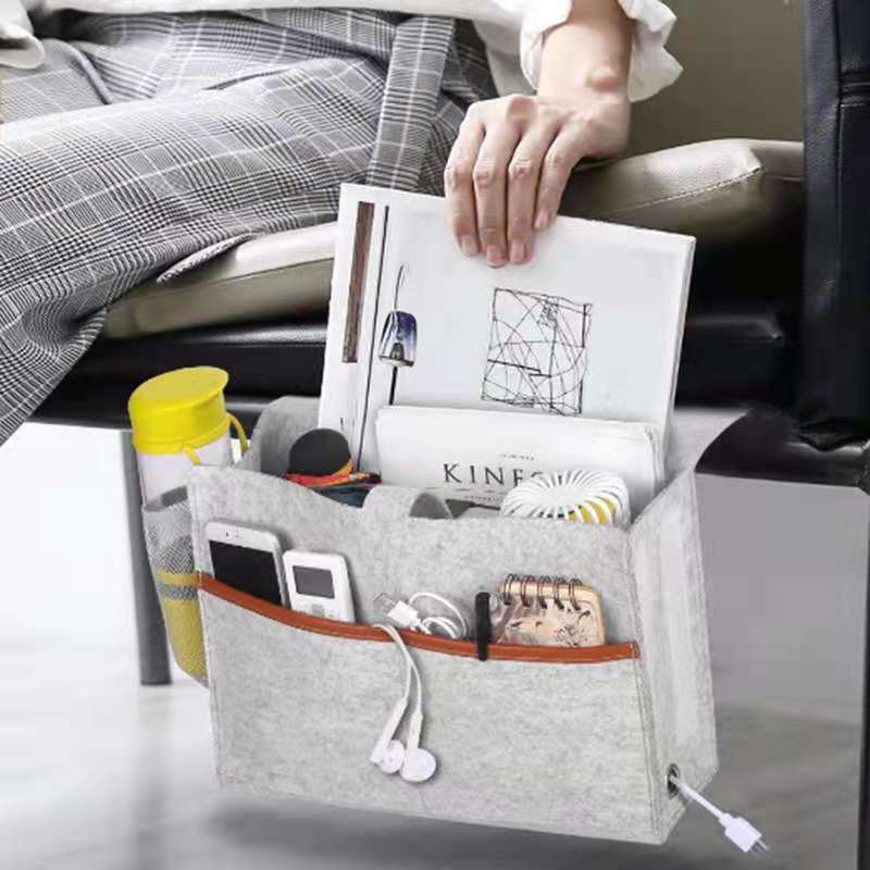 Gray caddy with compartments holding various items on a couch