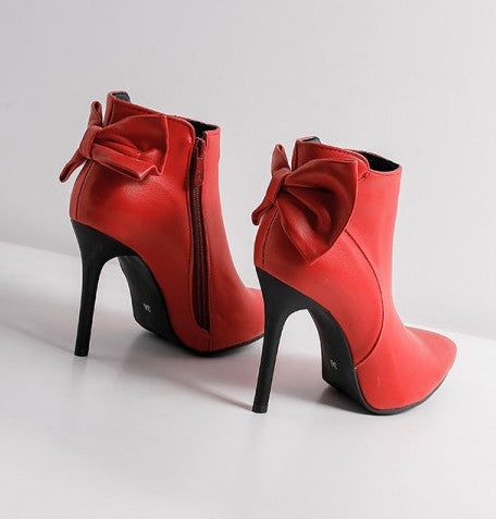 Red high-heeled ankle boots with bows on a white background