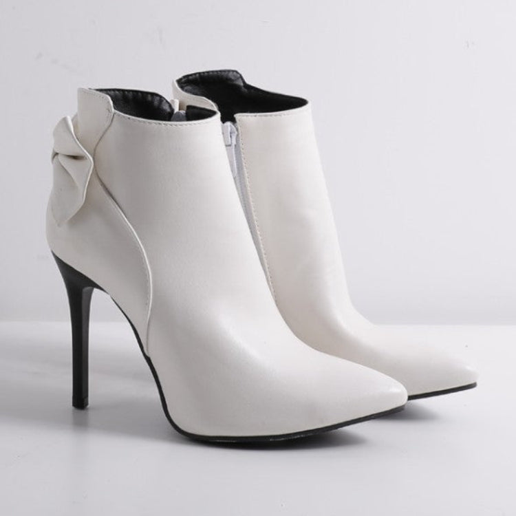 White high-heeled ankle boots on a light gray background