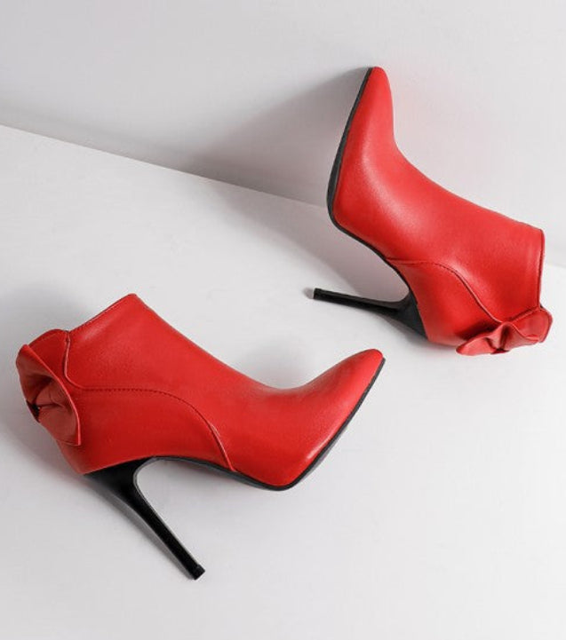 Red high-heeled shoes with black soles on a white background