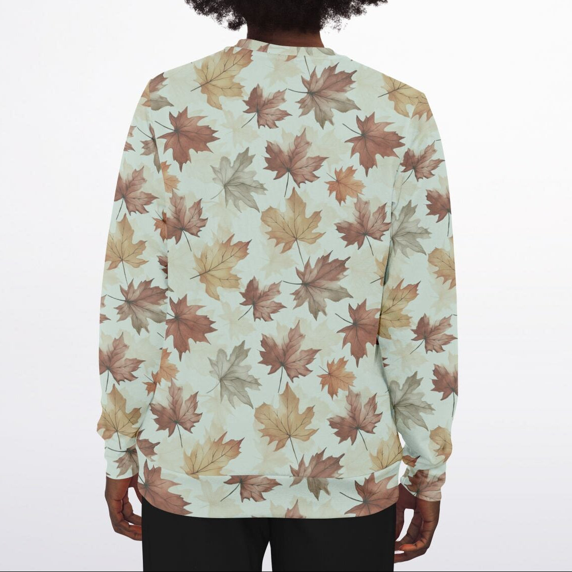 Person wearing a sweater with a leaf pattern on a plain background