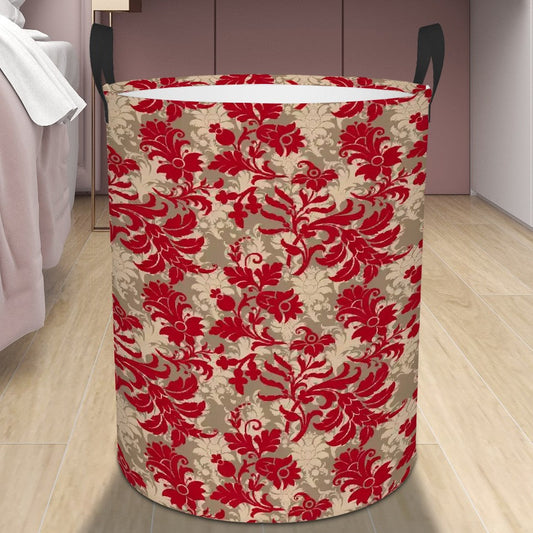 Decorative laundry basket with red floral pattern on a wooden floor next to a bed.